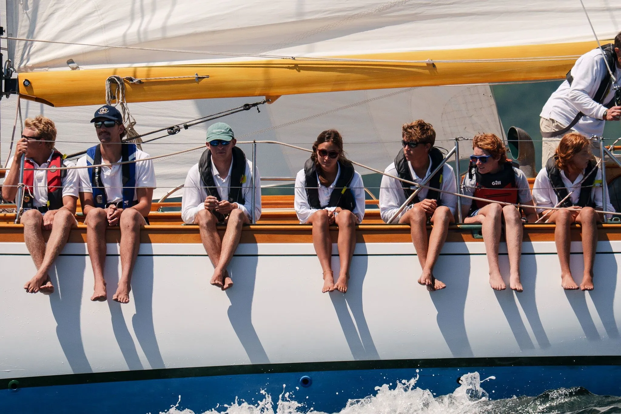 Crew hiked out along the rail, legs over the side, as the boat drives to windward, Penobscot Bay, ME
