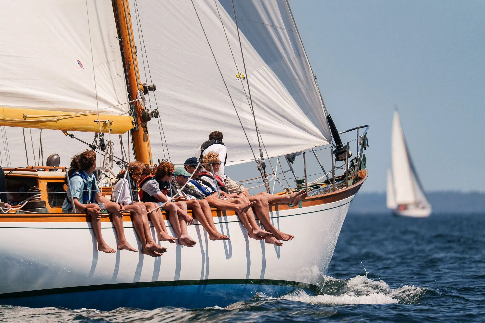 A classic yacht heeling hard with crew on the rail and a second boat astern, Penobscot Bay, ME